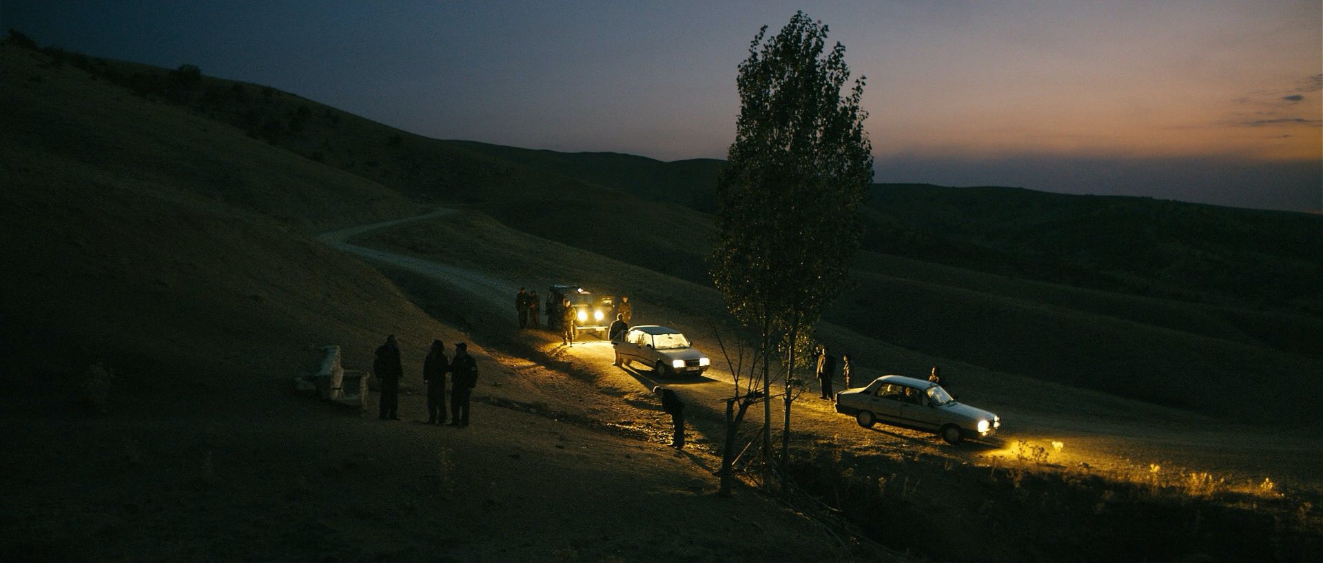 Night scene on a hillside road lit by car headlights, from Once Upon a Time in Anatolia